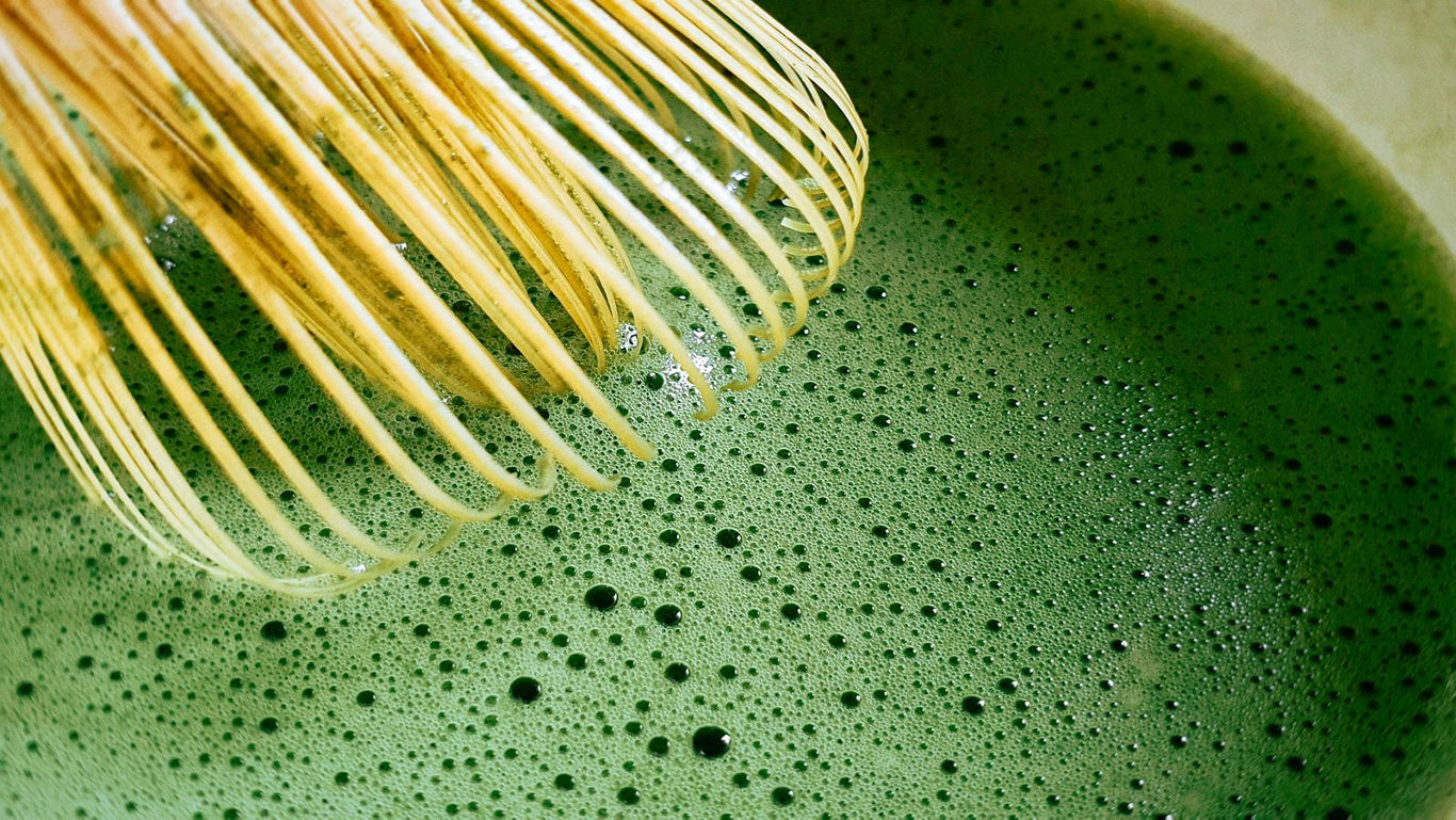 A top-view image of matcha and its preparation tools.