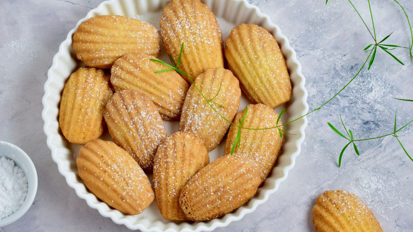Freshly baked madeleines dusted with sugar