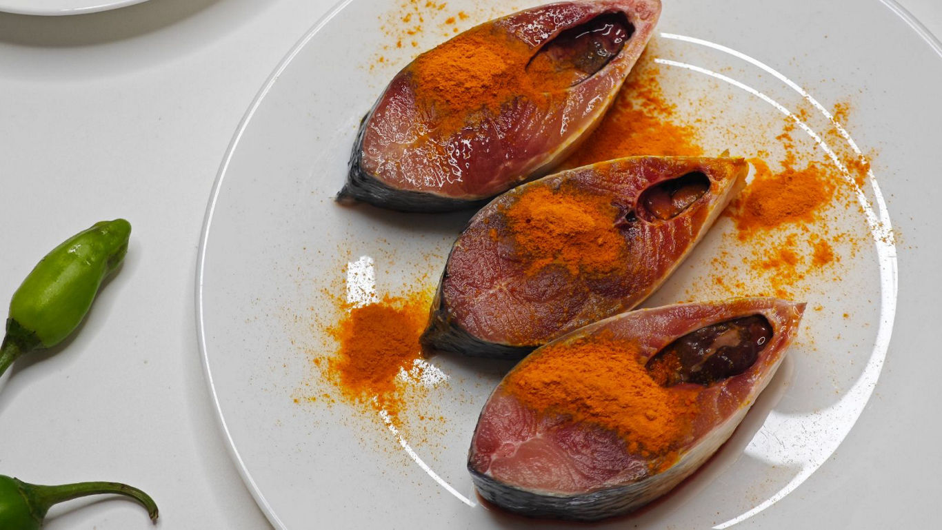Raw fish steaks seasoned with turmeric powder