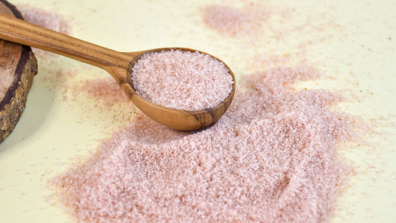 Wooden spoon filled with pink salt