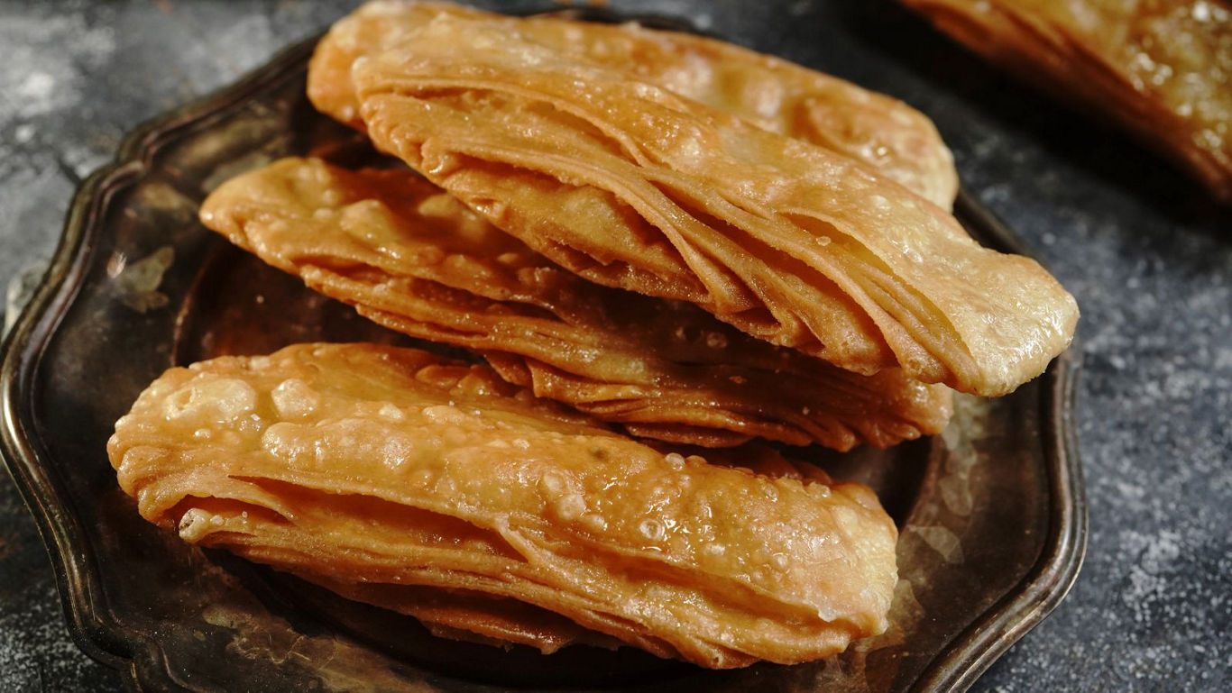 Stacked fried layered pastries on plate