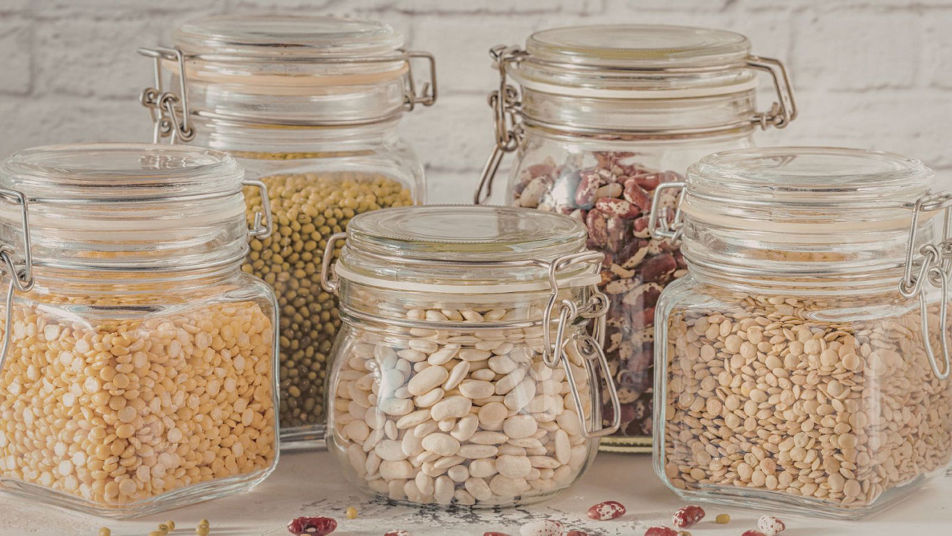 Assorted dry legumes stored in glass jars