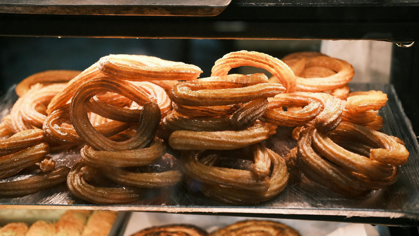 Fresh churros stacked in bakery display