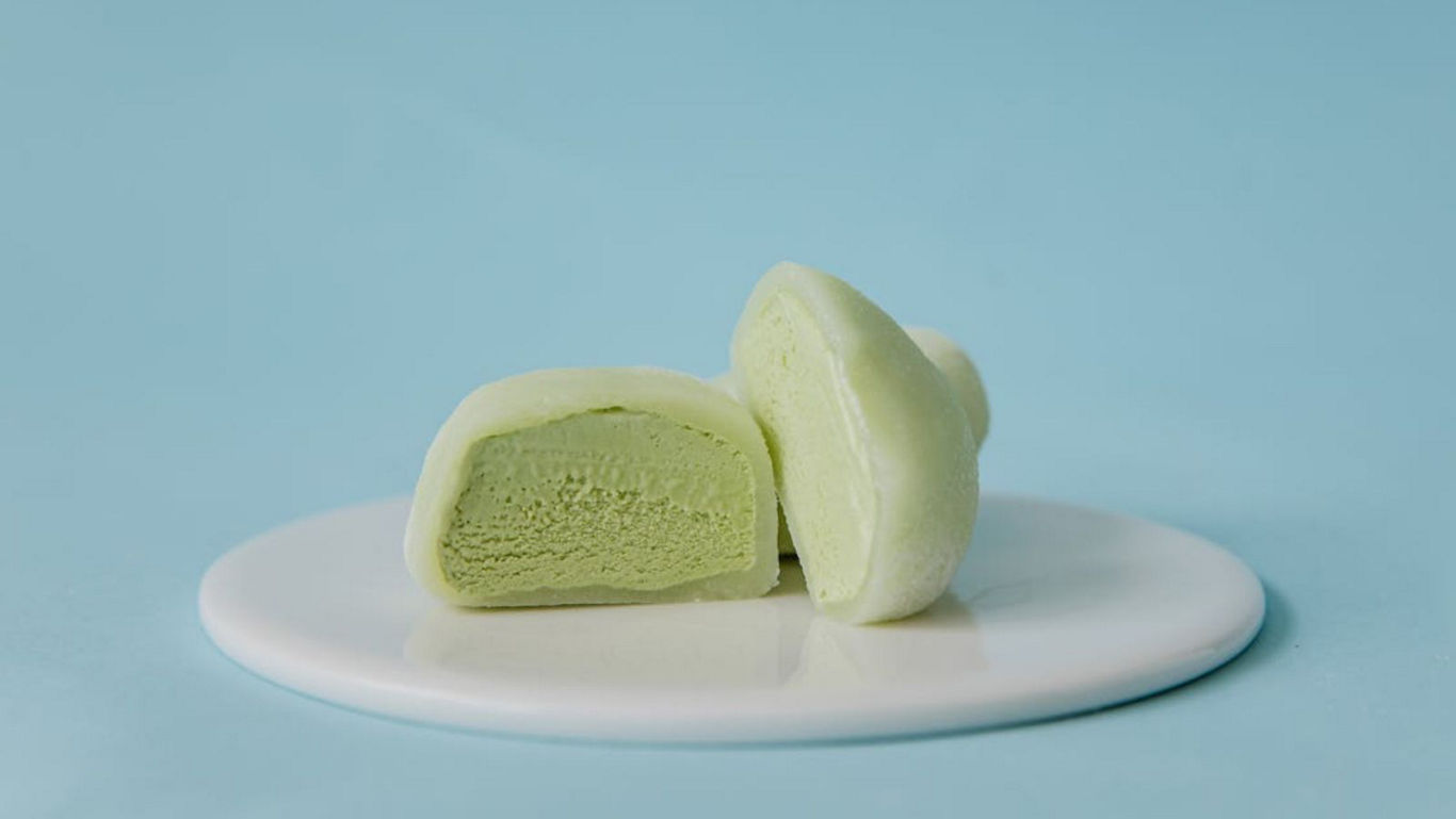 Green mochi ice cream halves on white plate