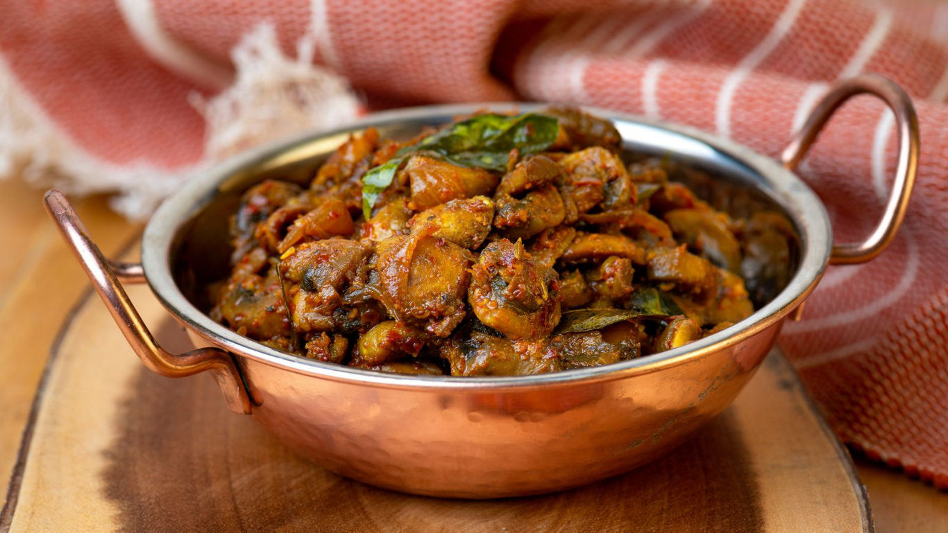 Spiced mushroom curry in copper bowl