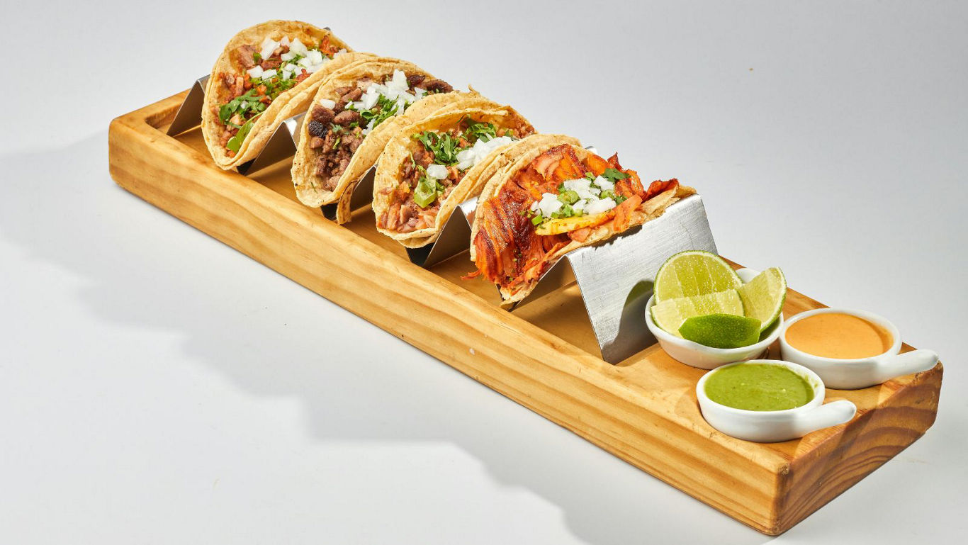 Assorted Mexican tacos with sauces and lime