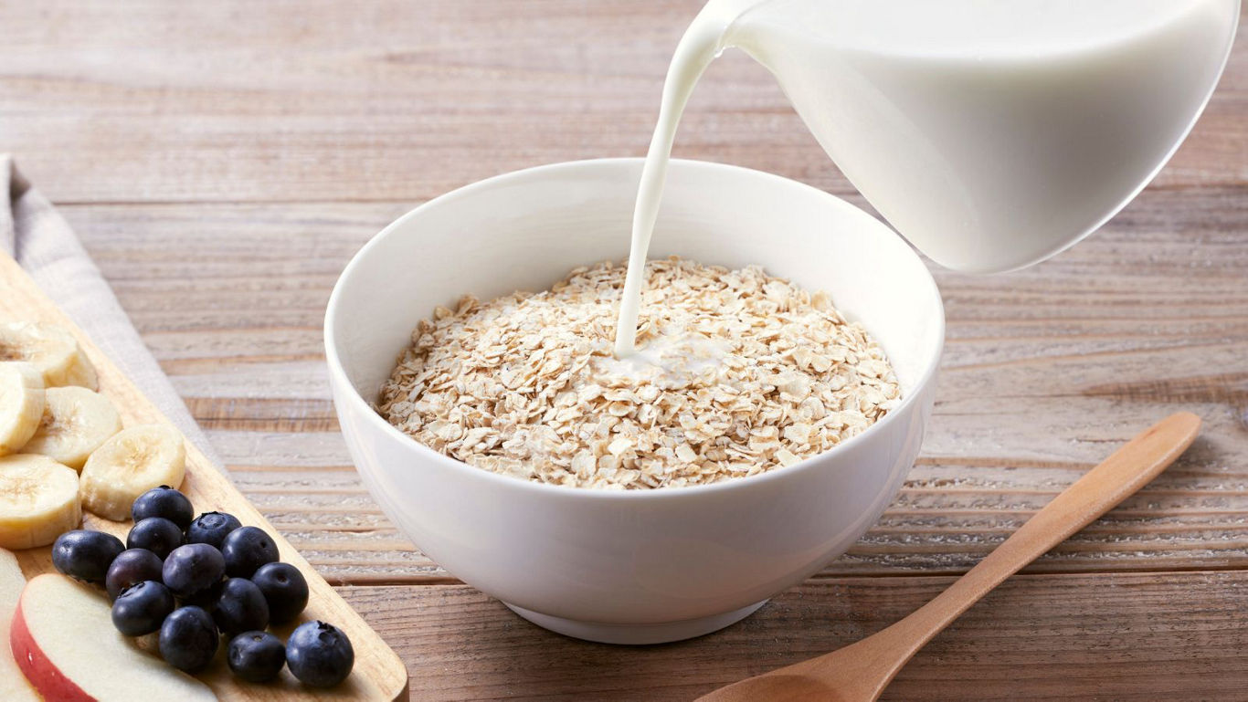 Milk poured over oatmeal with fresh fruit