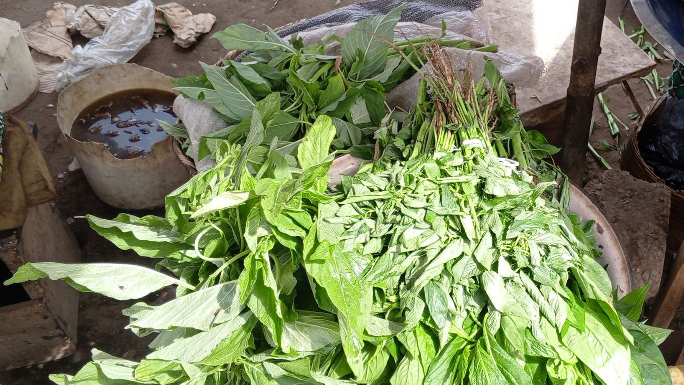 Fresh green leafy vegetables at outdoor market stall