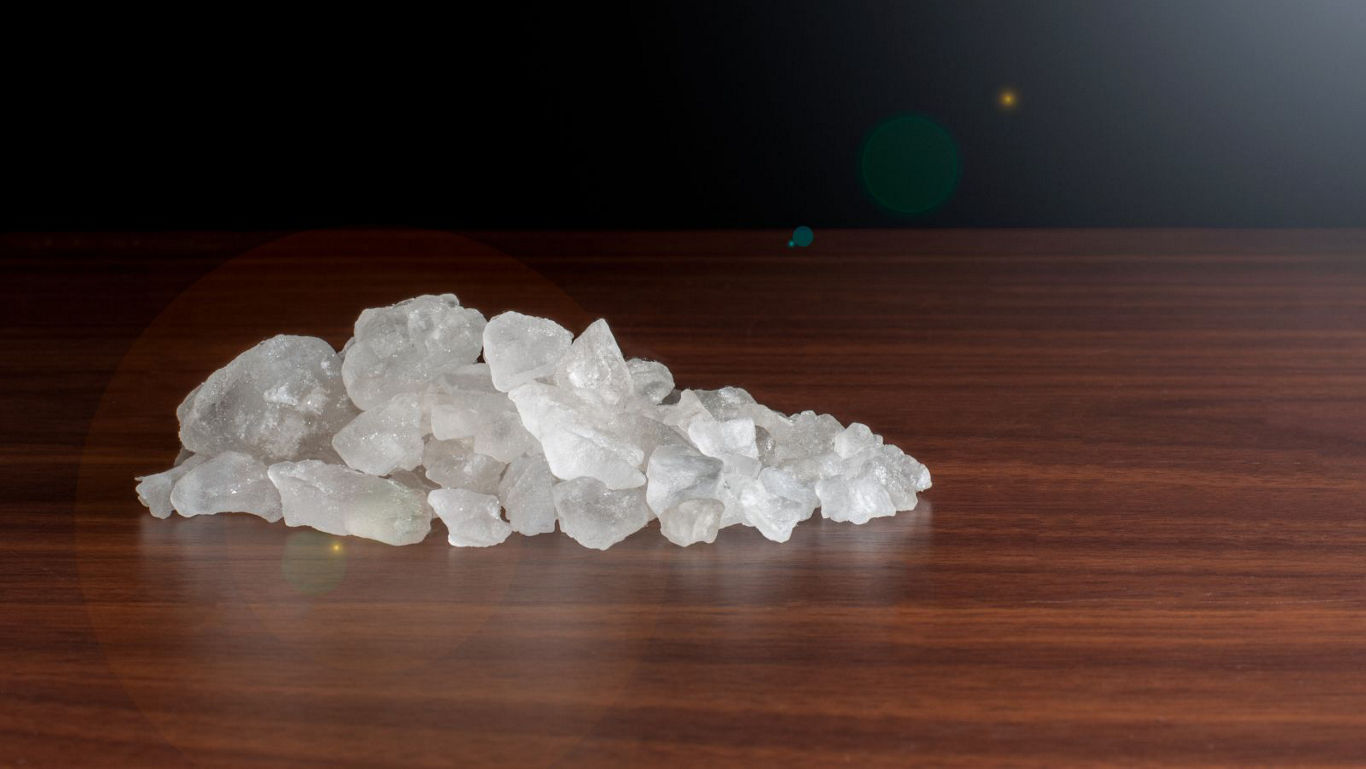 Pile of white crystals on wooden table