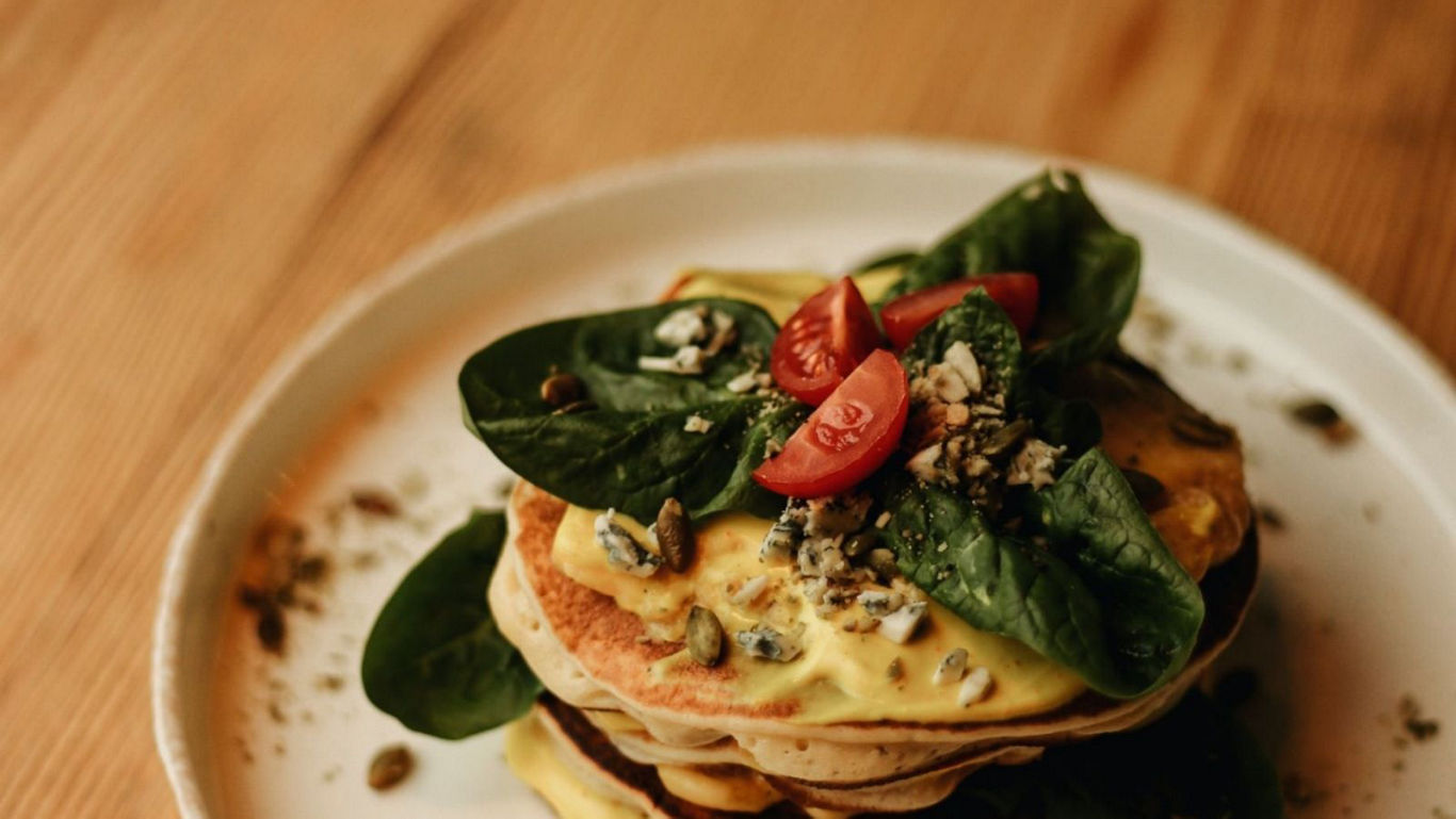 Stack of savory pancakes with fresh toppings