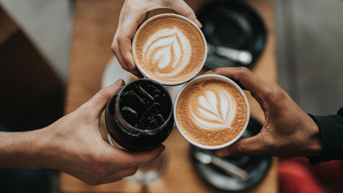 Friends toasting with artisan coffee drinks