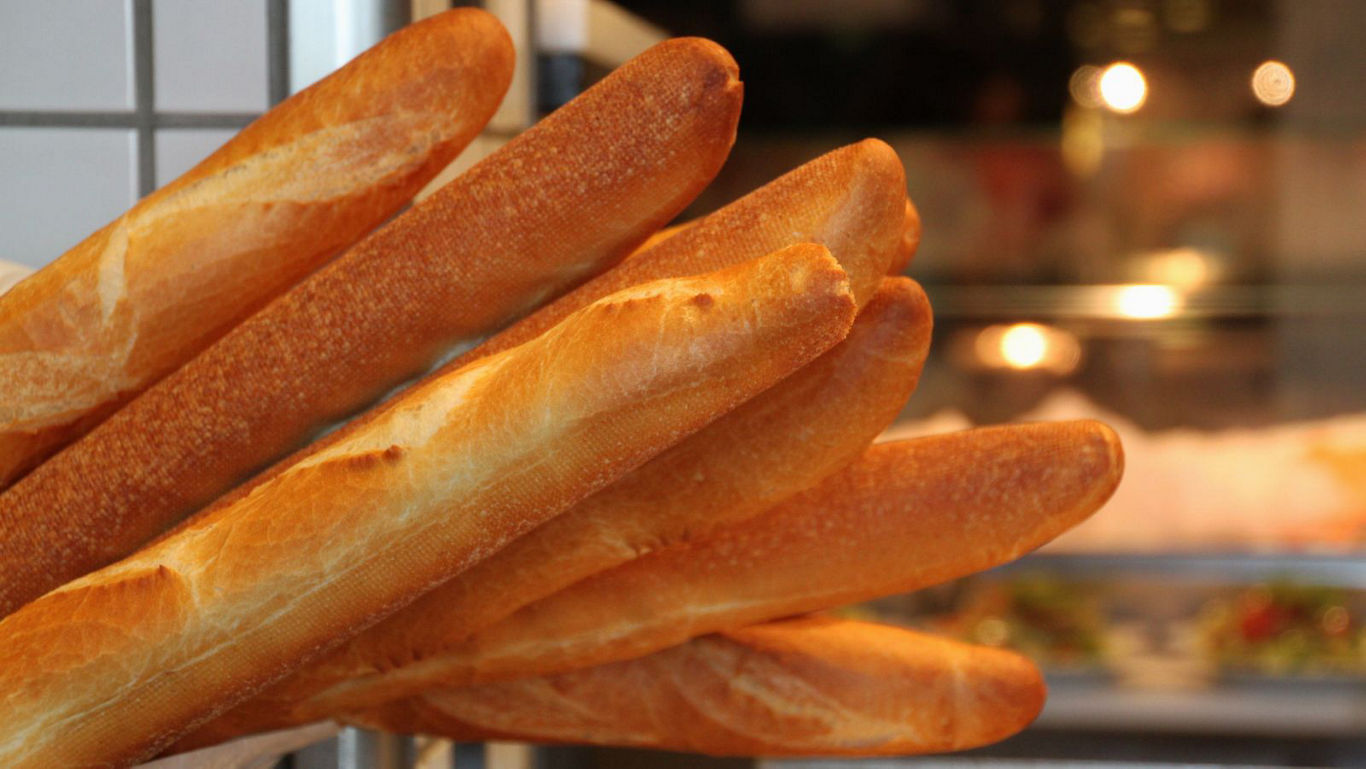 Fresh golden baguettes stacked in bakery display