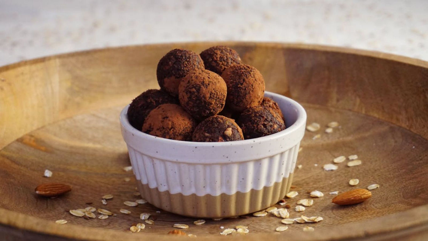 Chocolate truffles in ceramic bowl on wooden tray