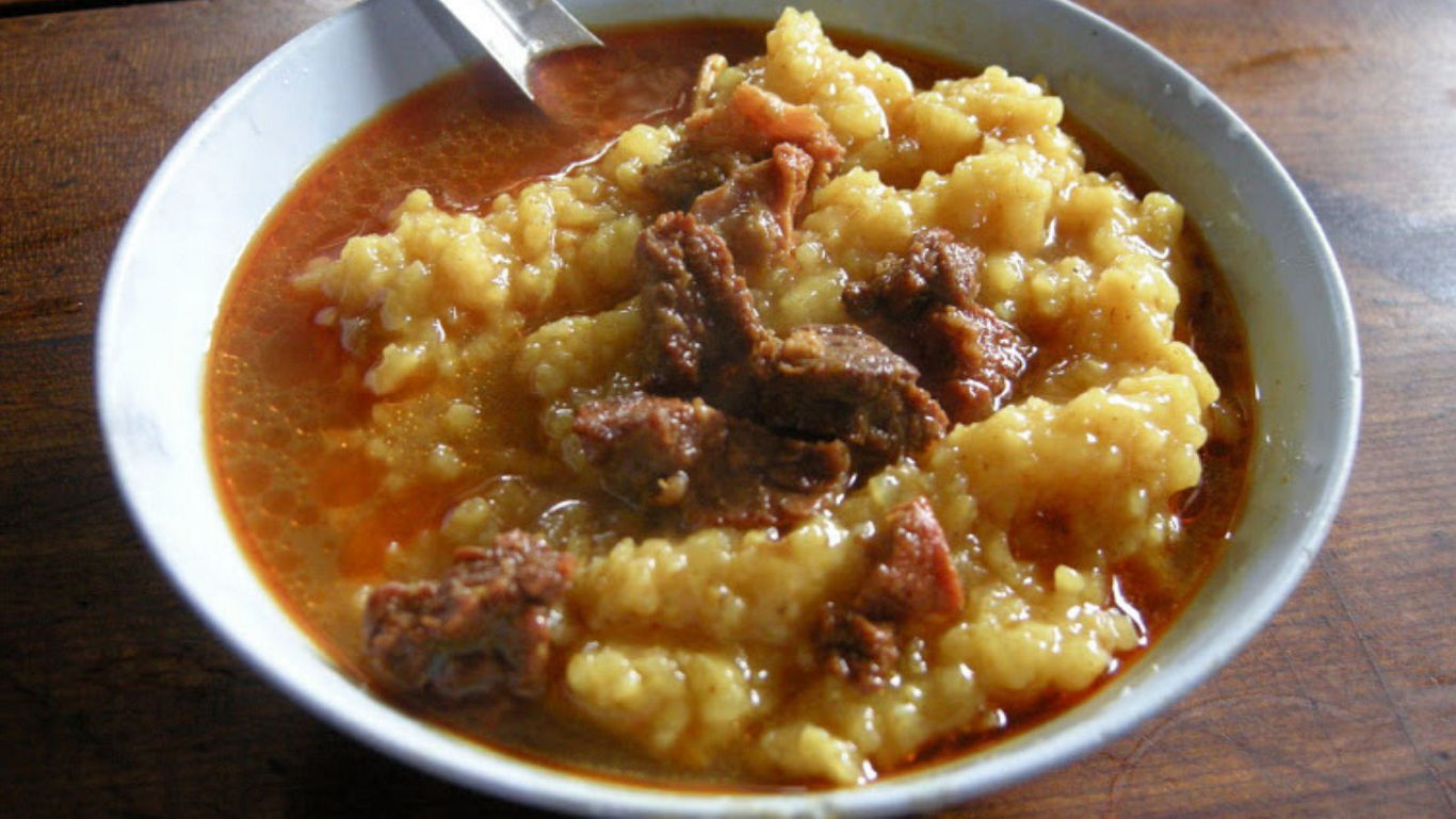 Hearty meat stew with dumplings in bowl