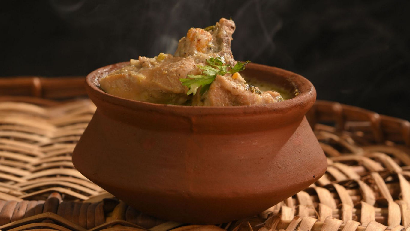Steaming curry served in rustic clay pot