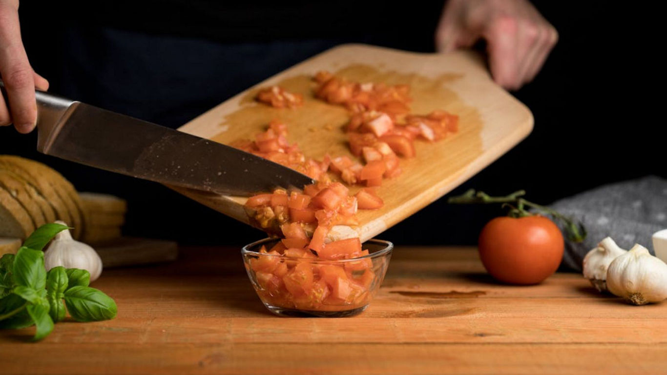 Chopped Tomatoes Transferred Into Glass Bowl on Table