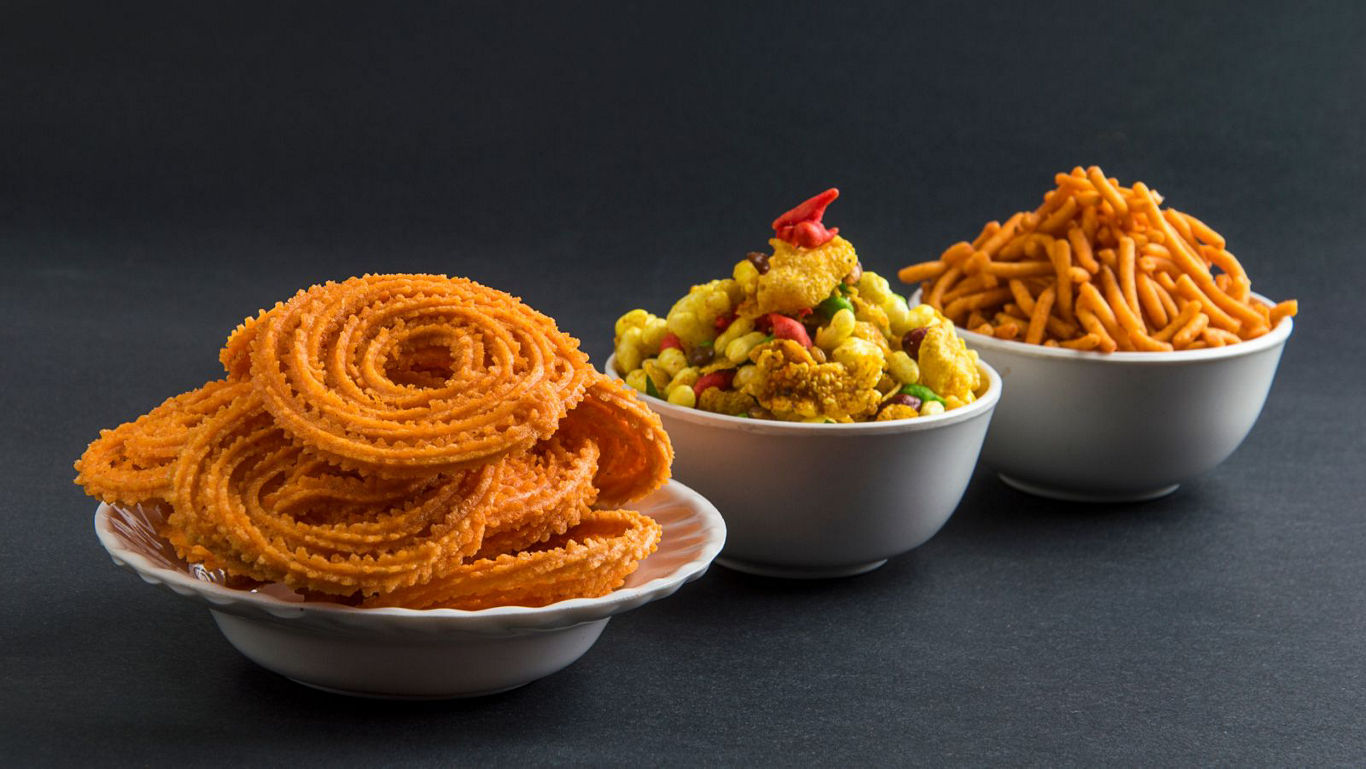 Indian savory snacks in white bowls