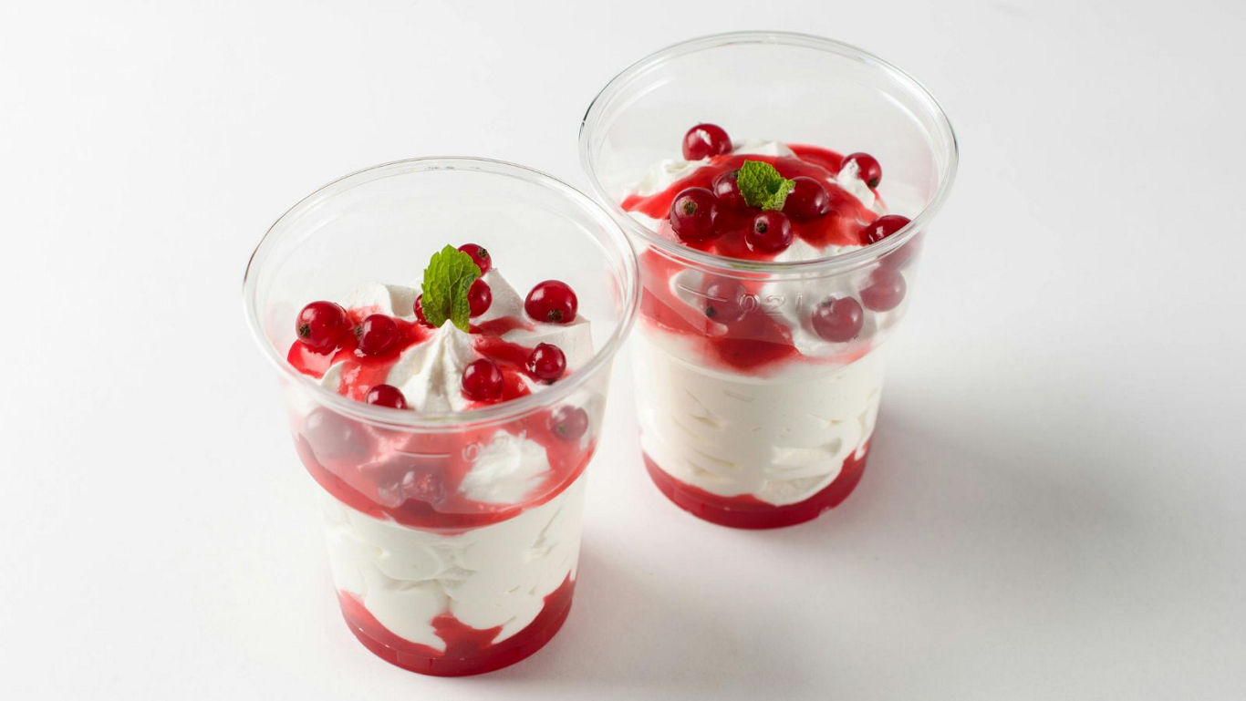 Two dessert cups with whipped cream and berries