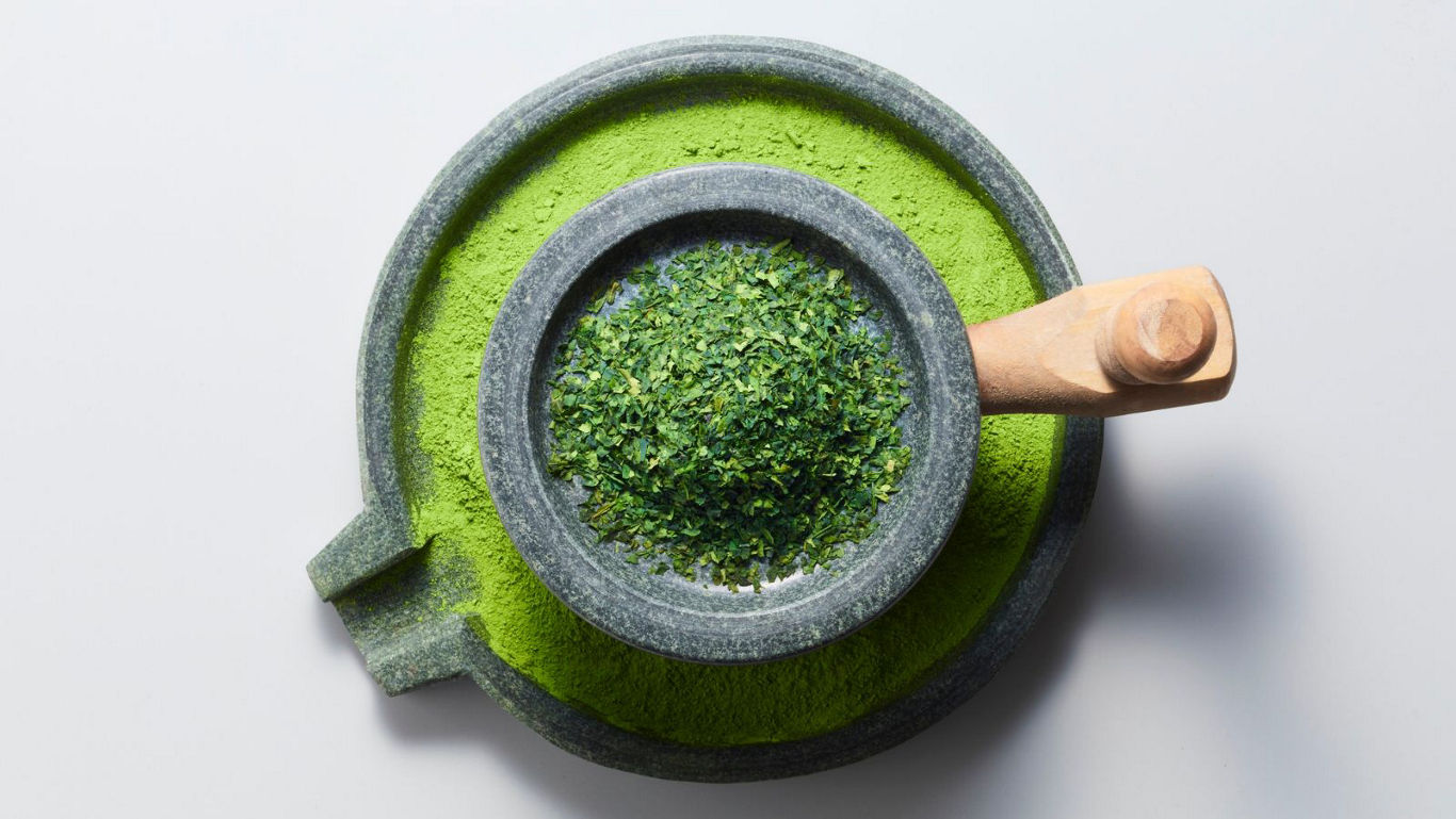 Stone mortar grinding green tea leaves