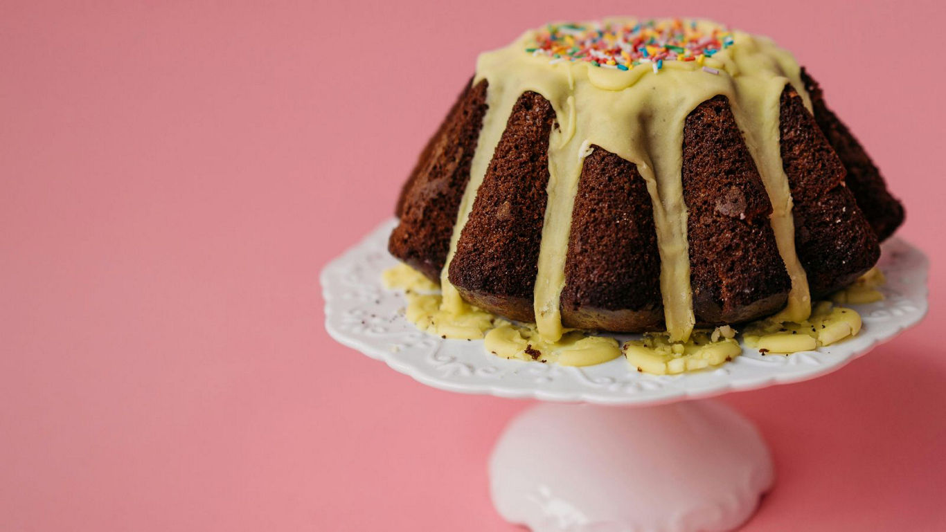 Bundt cake with icing on pink background