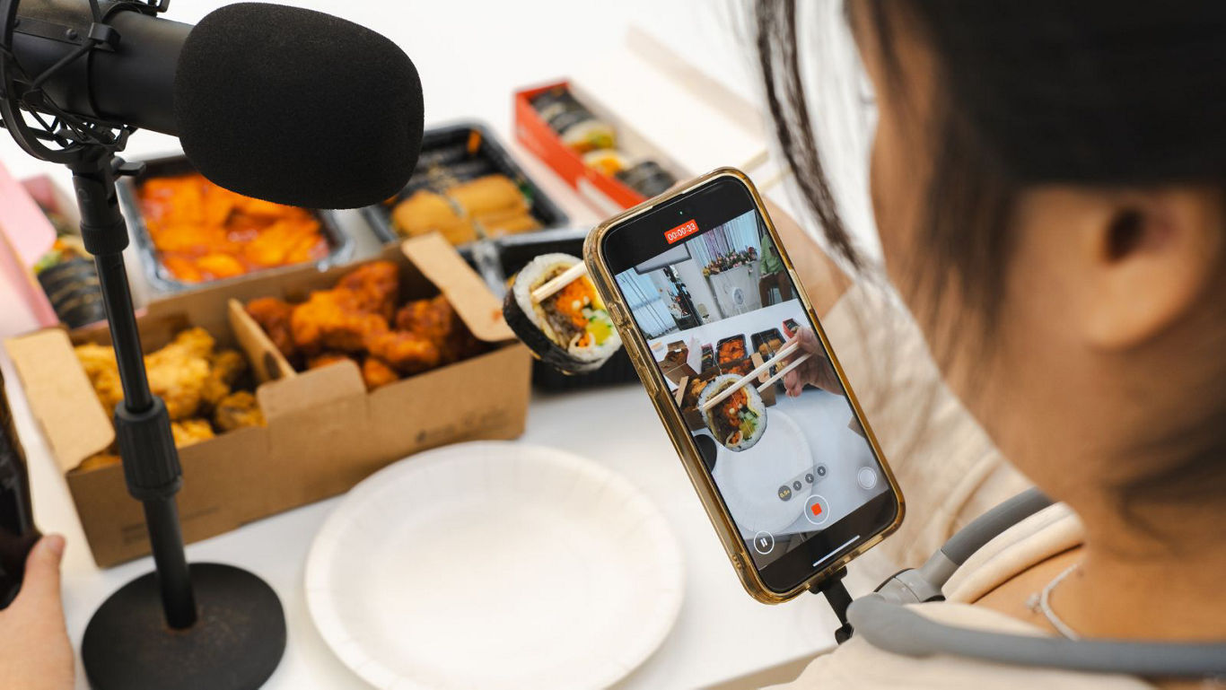 Food content creator recording meal with smartphone