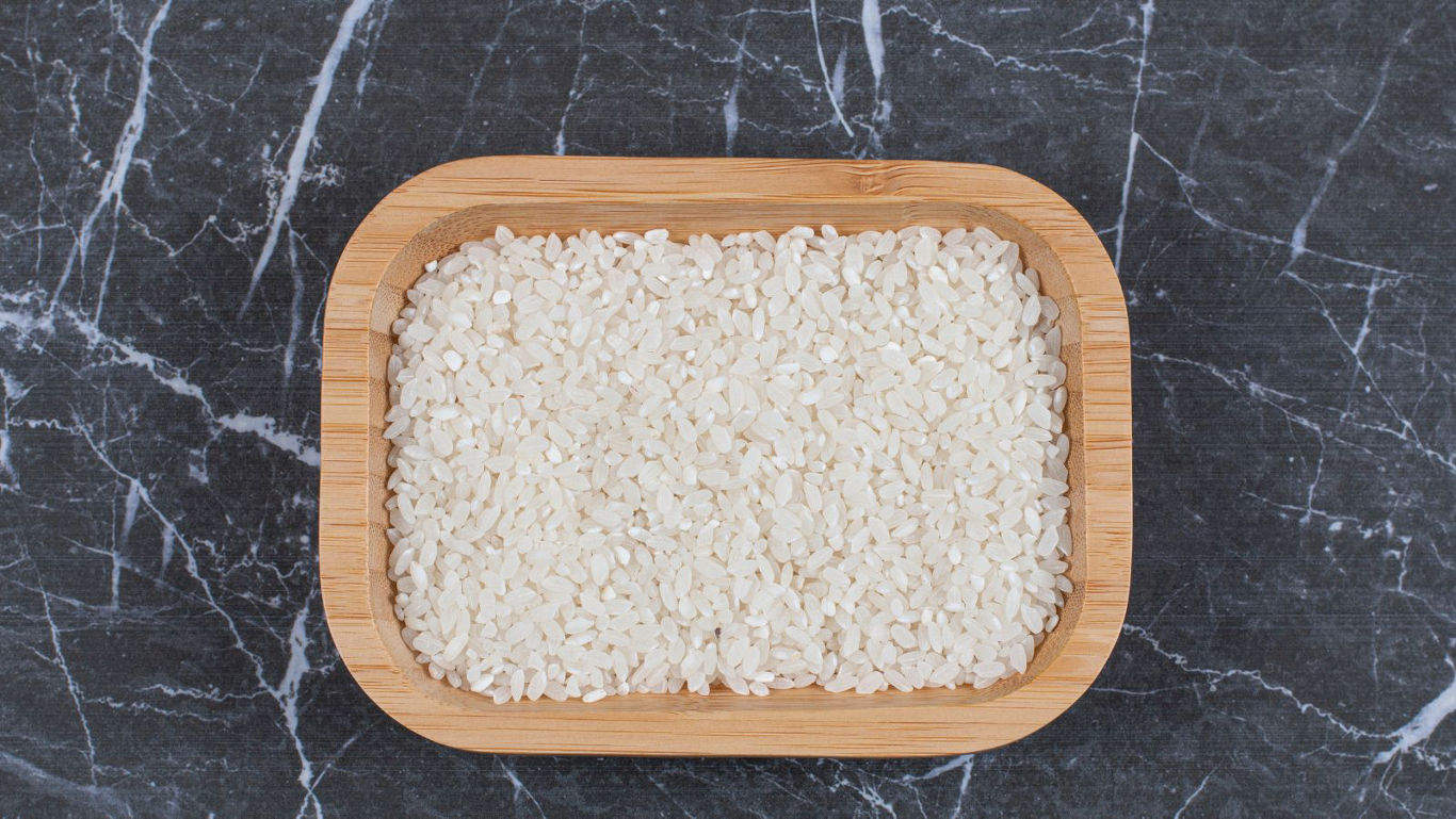 Wooden tray filled with uncooked white rice