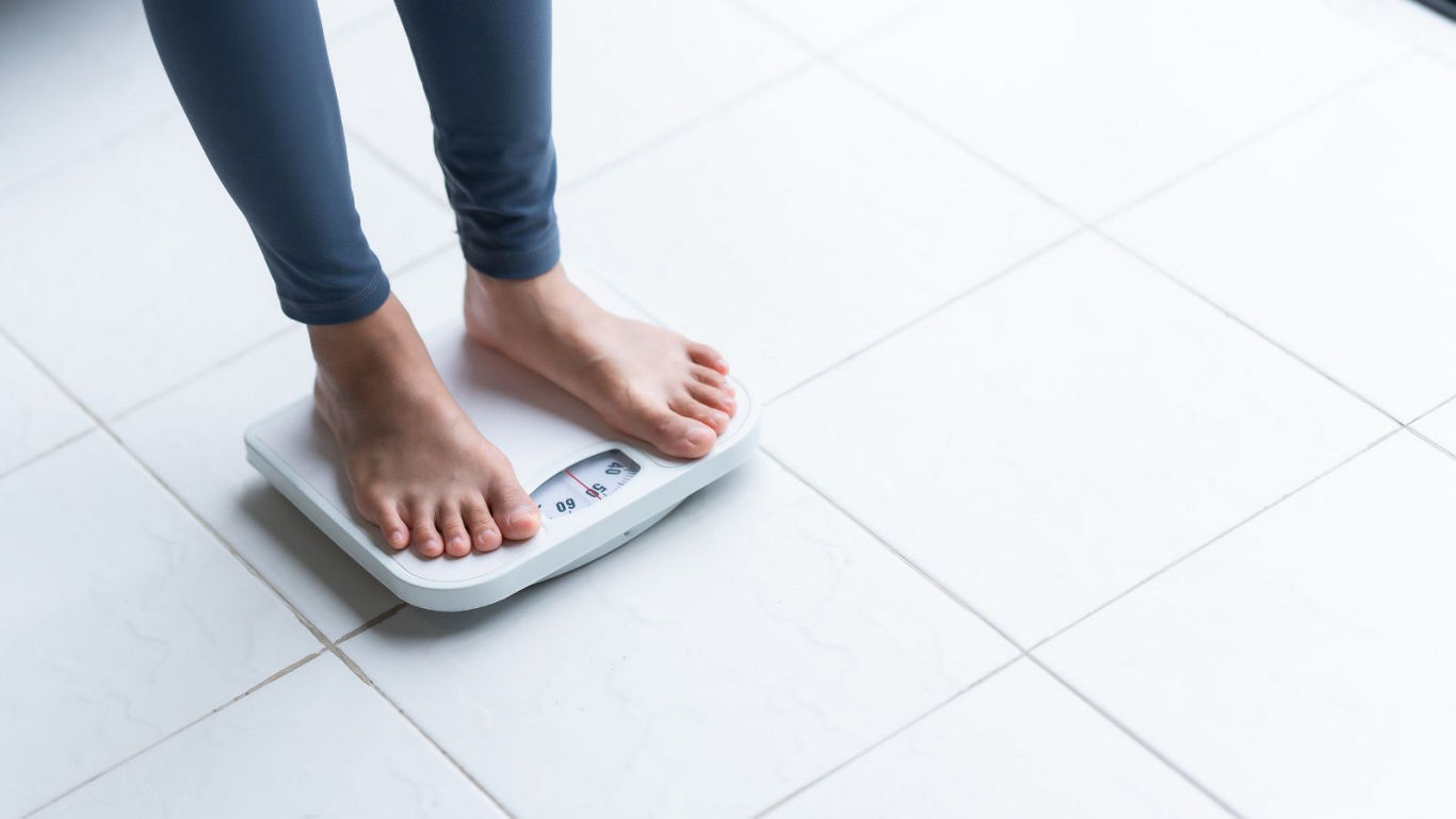 Person standing on digital bathroom scale indoors