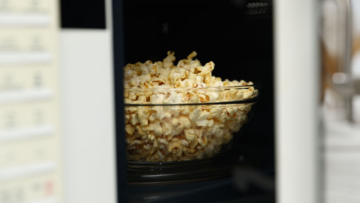 Glass bowl of popcorn in microwave