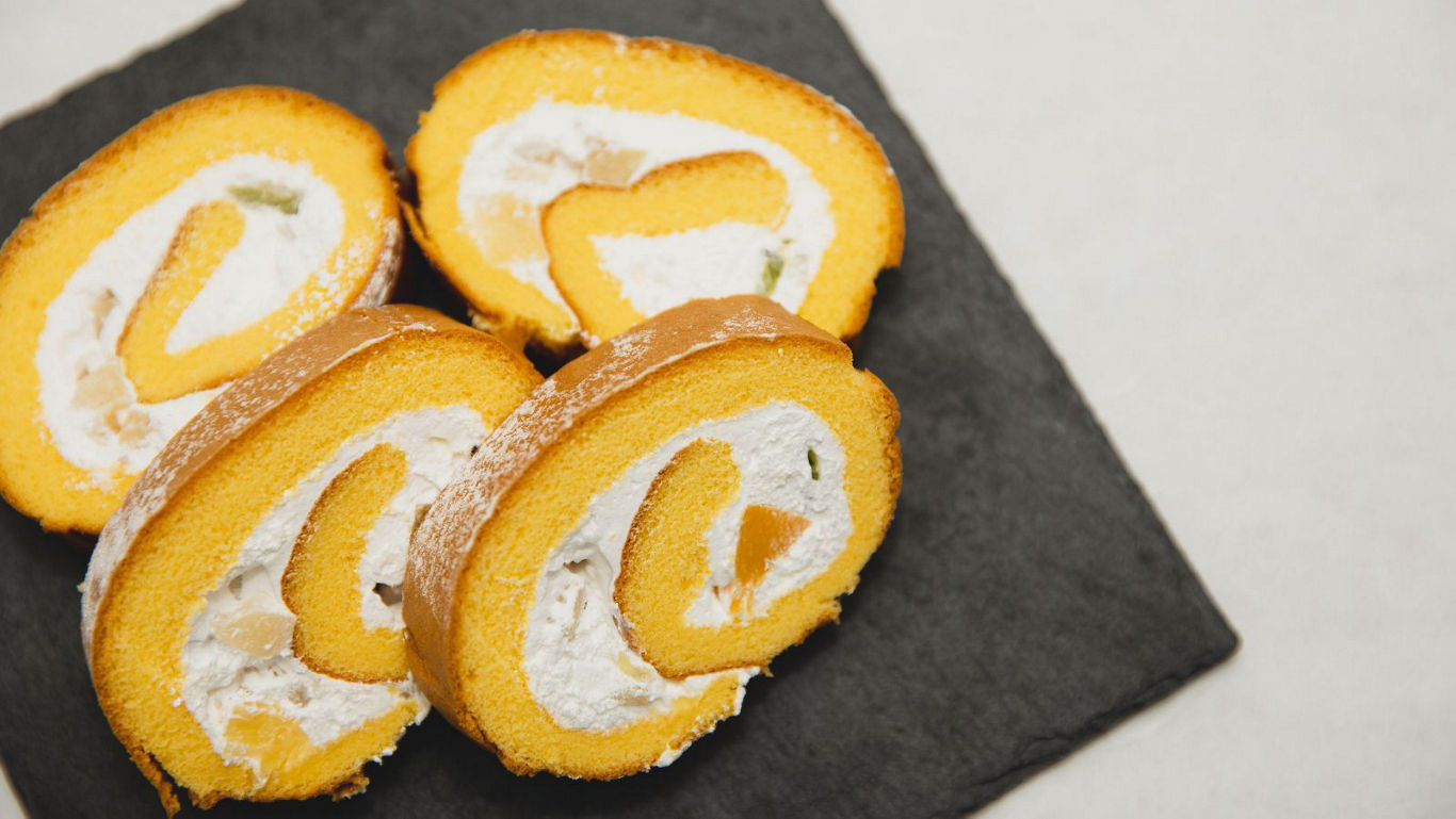 Sliced cream-filled Swiss roll cake dessert