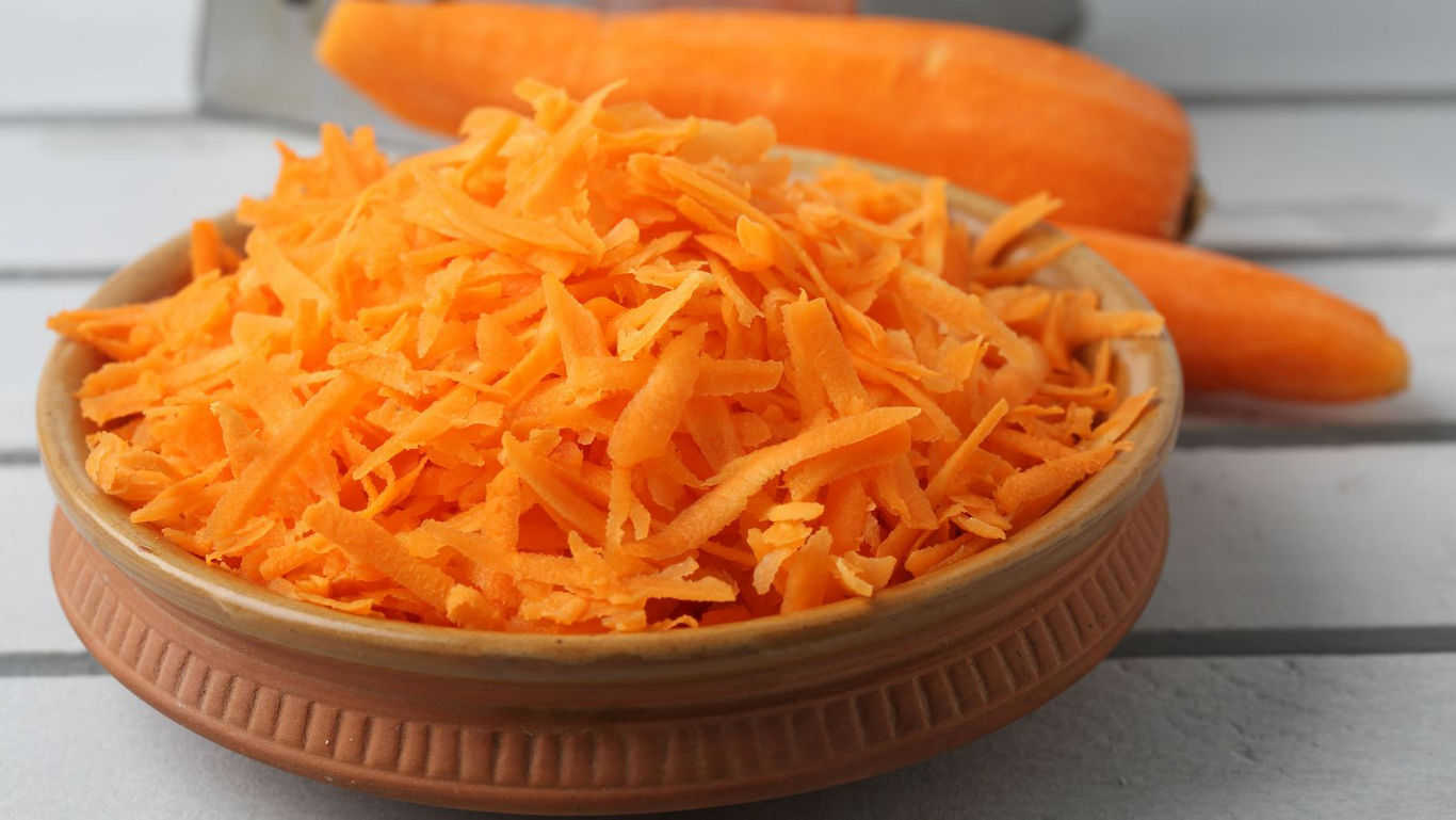 Freshly grated carrots in a ceramic bowl