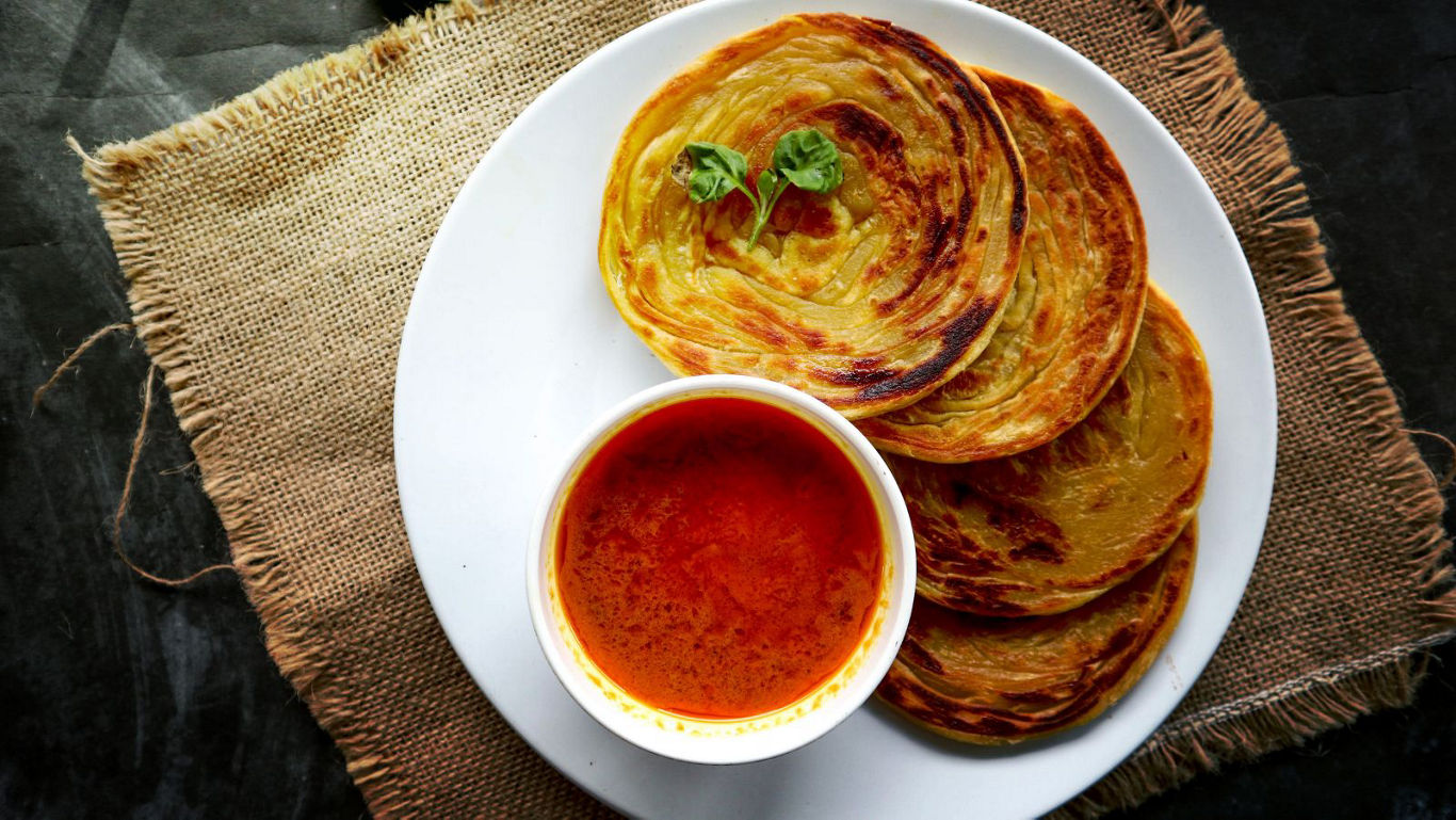 Crispy Parotta with Spicy Curry on White Plate