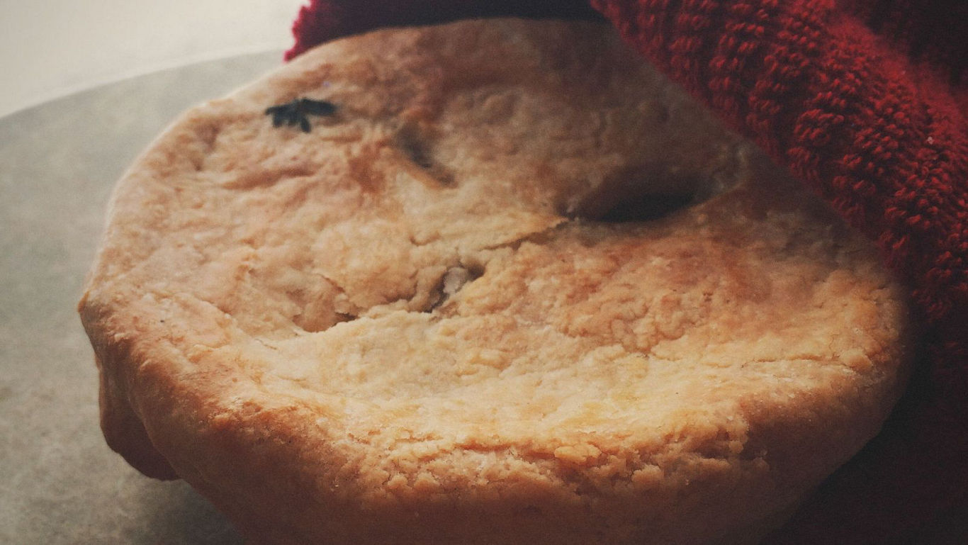 Freshly baked savory pie under cloth