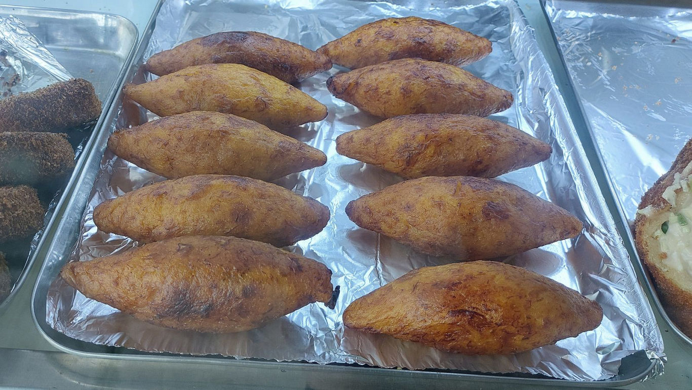 Tray of fried stuffed plantain pastries
