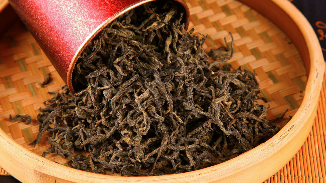 Loose leaf tea spilling from red container