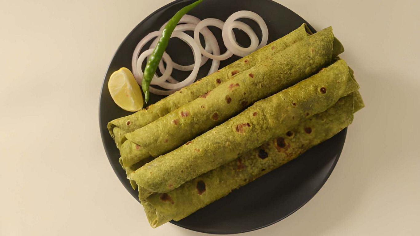 Green spinach parathas served with onion and lemon