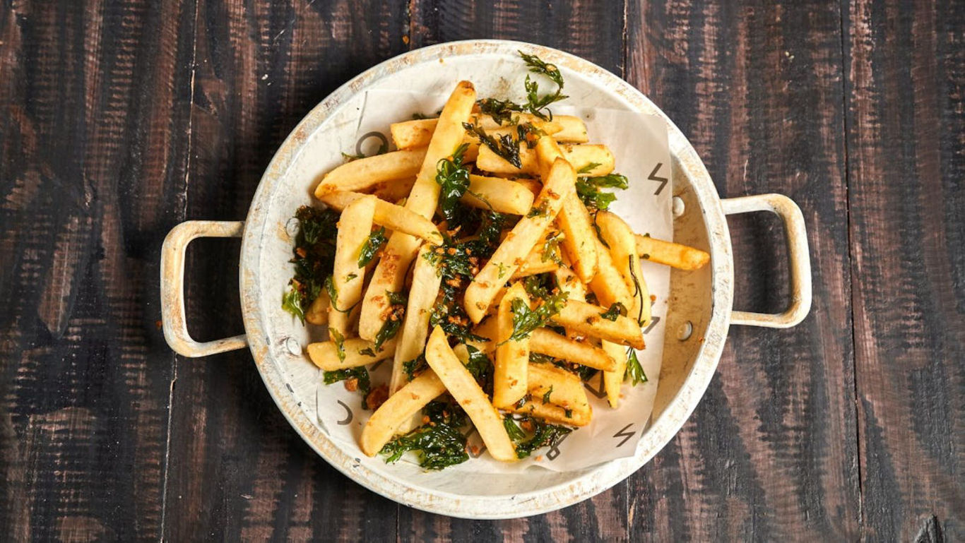Crispy French Fries with Herbs in Rustic Bowl