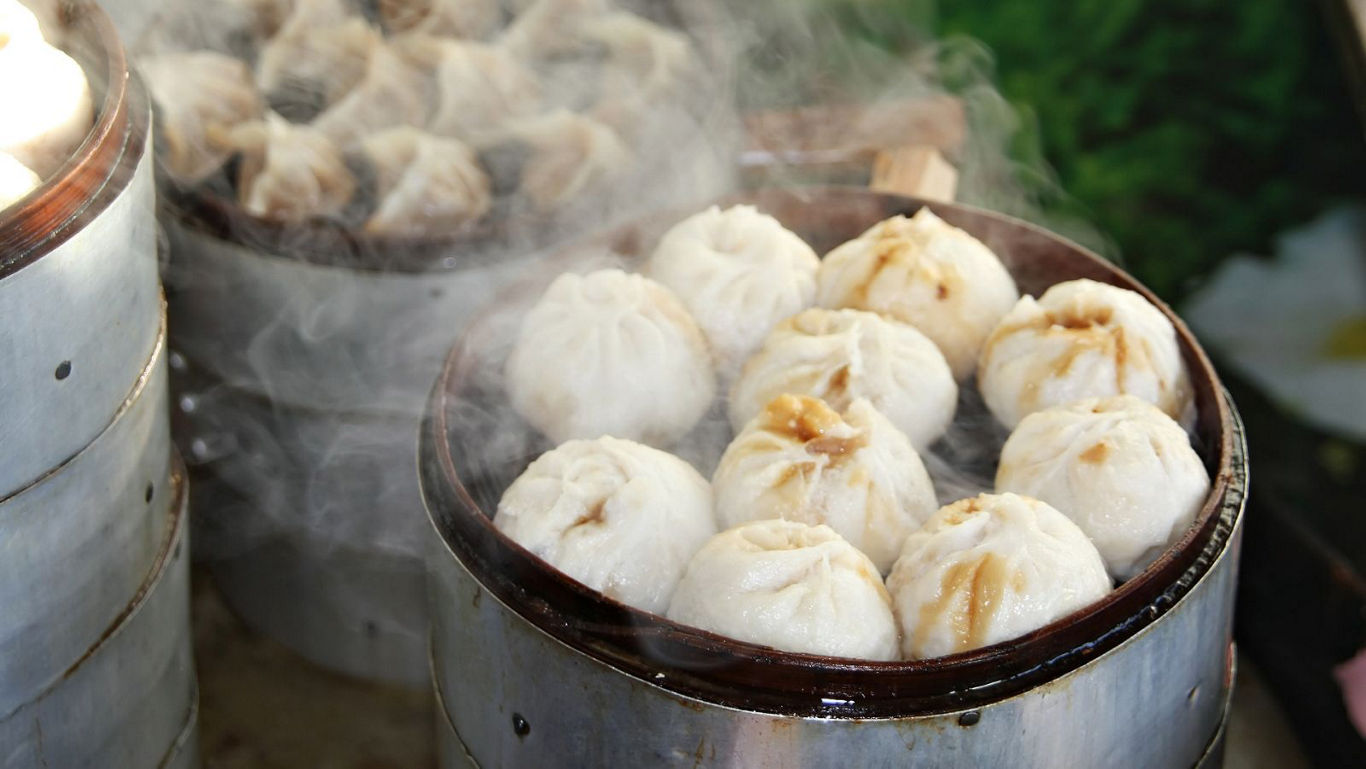 Steaming hot buns in traditional bamboo steamer