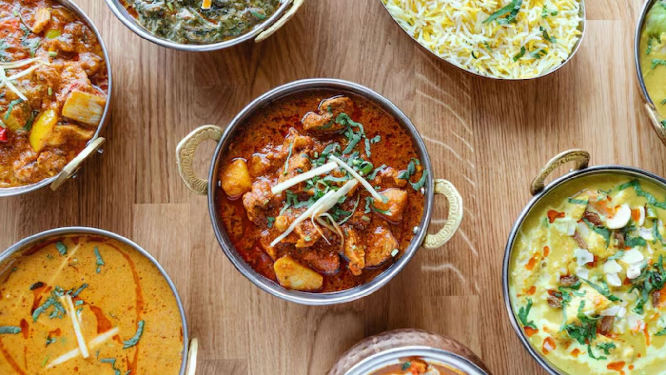 Assorted Indian Curries and Rice on Wooden Table
