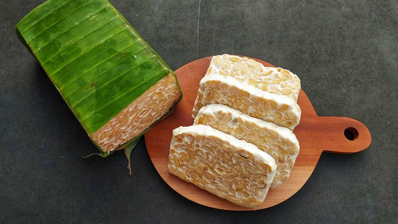 Sliced tempeh on wooden cutting board