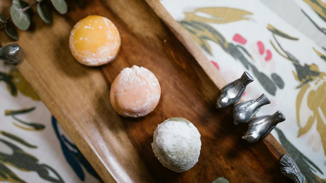 Colorful mochi desserts on wooden tray