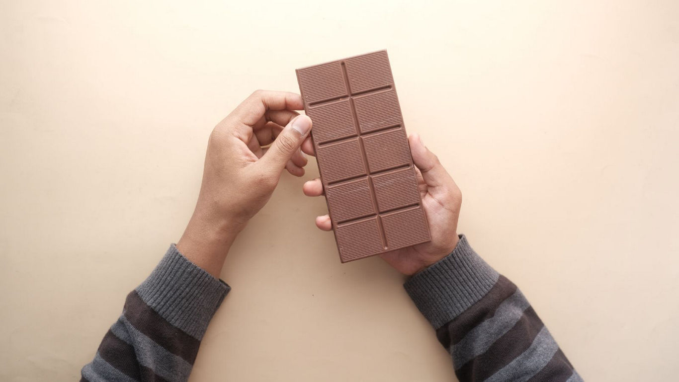 Hands holding a plain chocolate bar