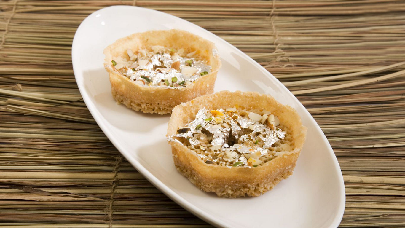 Two nut-filled dessert tarts on plate