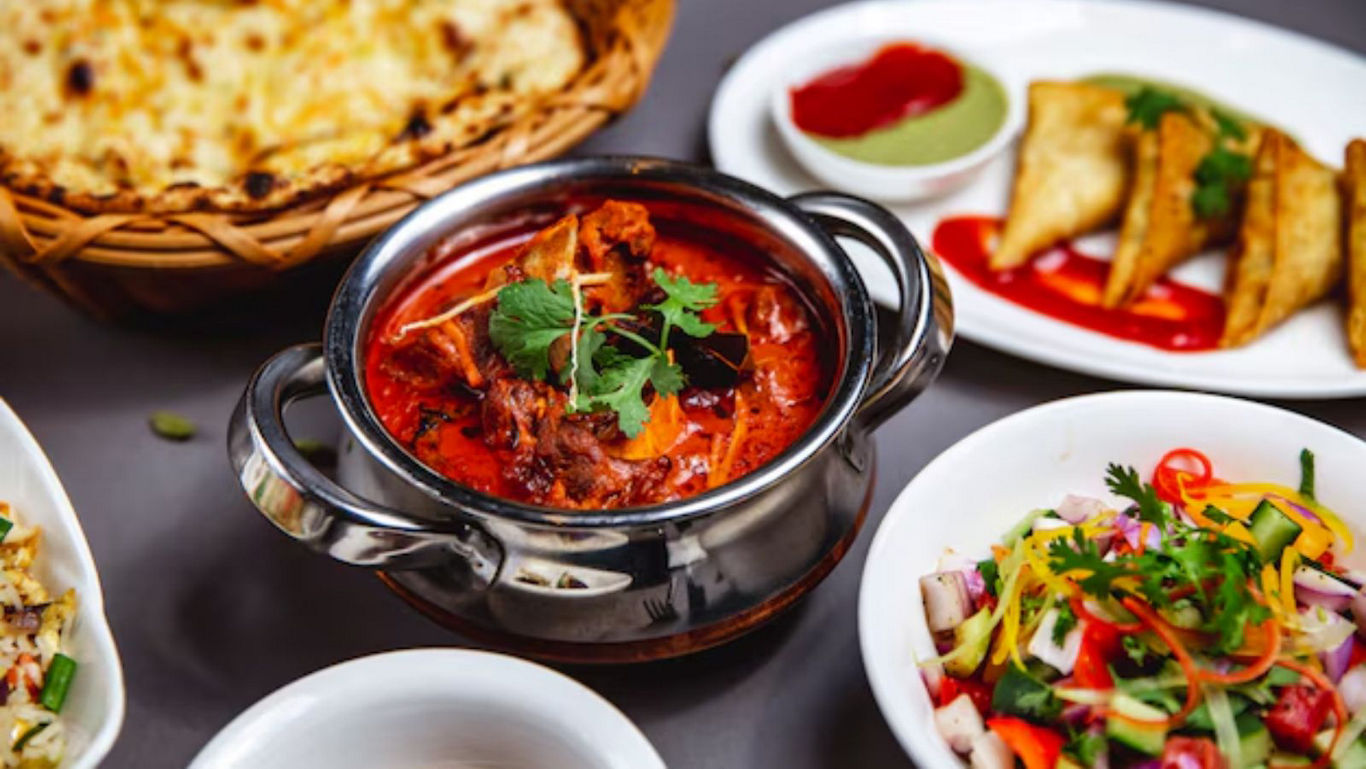 Traditional Indian curry with naan and assorted sides