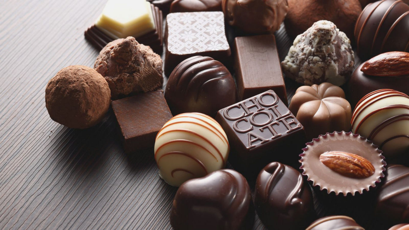 Assorted gourmet chocolates on wooden surface