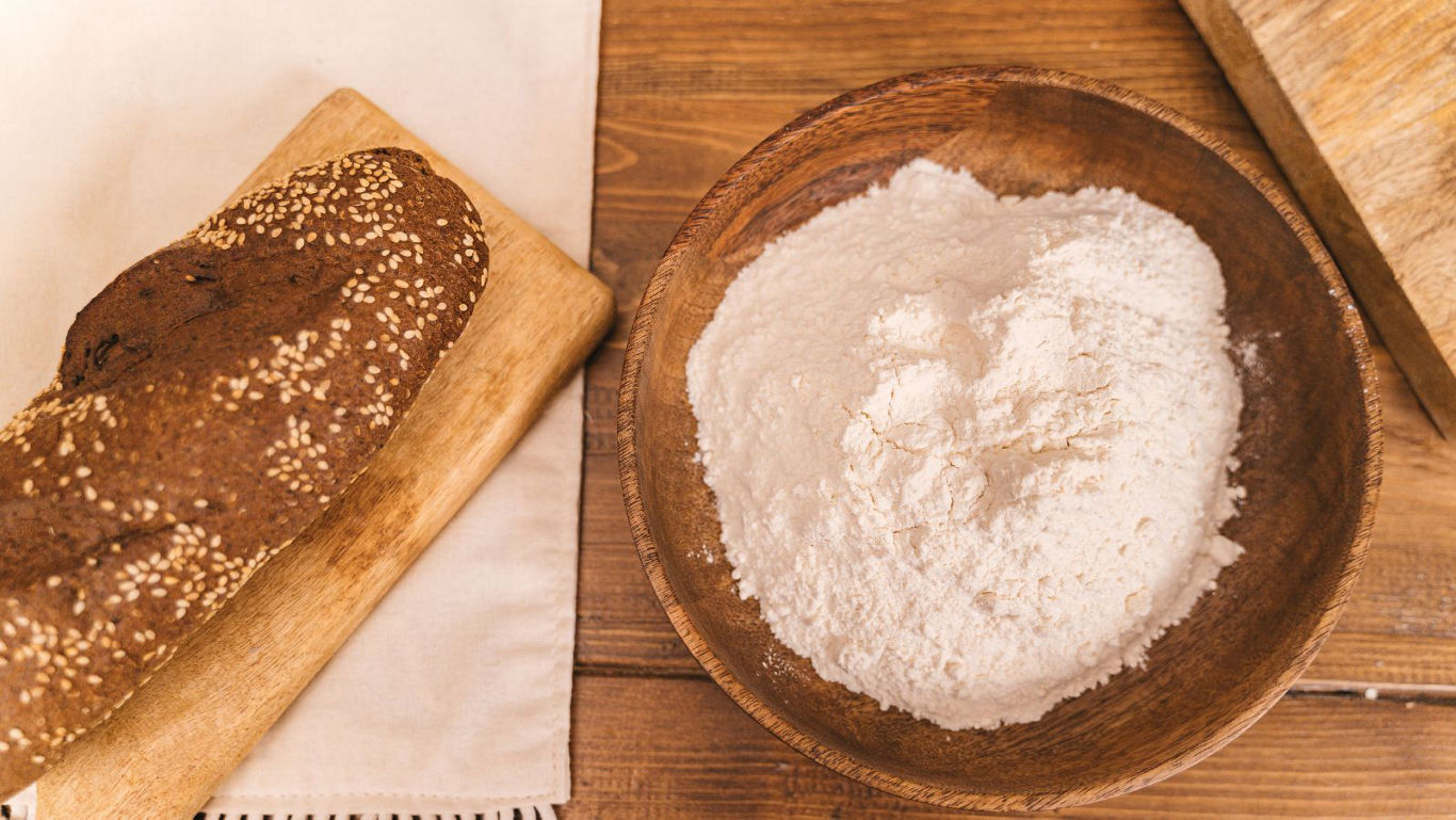 Rustic bread loaf and bowl of flour