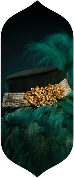 Traditional gold choker necklace with pearl strings displayed on a dark green velvet stand