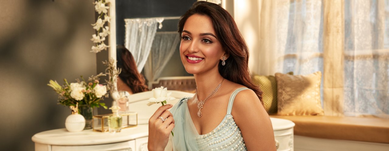 Graceful woman in light blue dress with delicate silver jewellery, holding a white rose