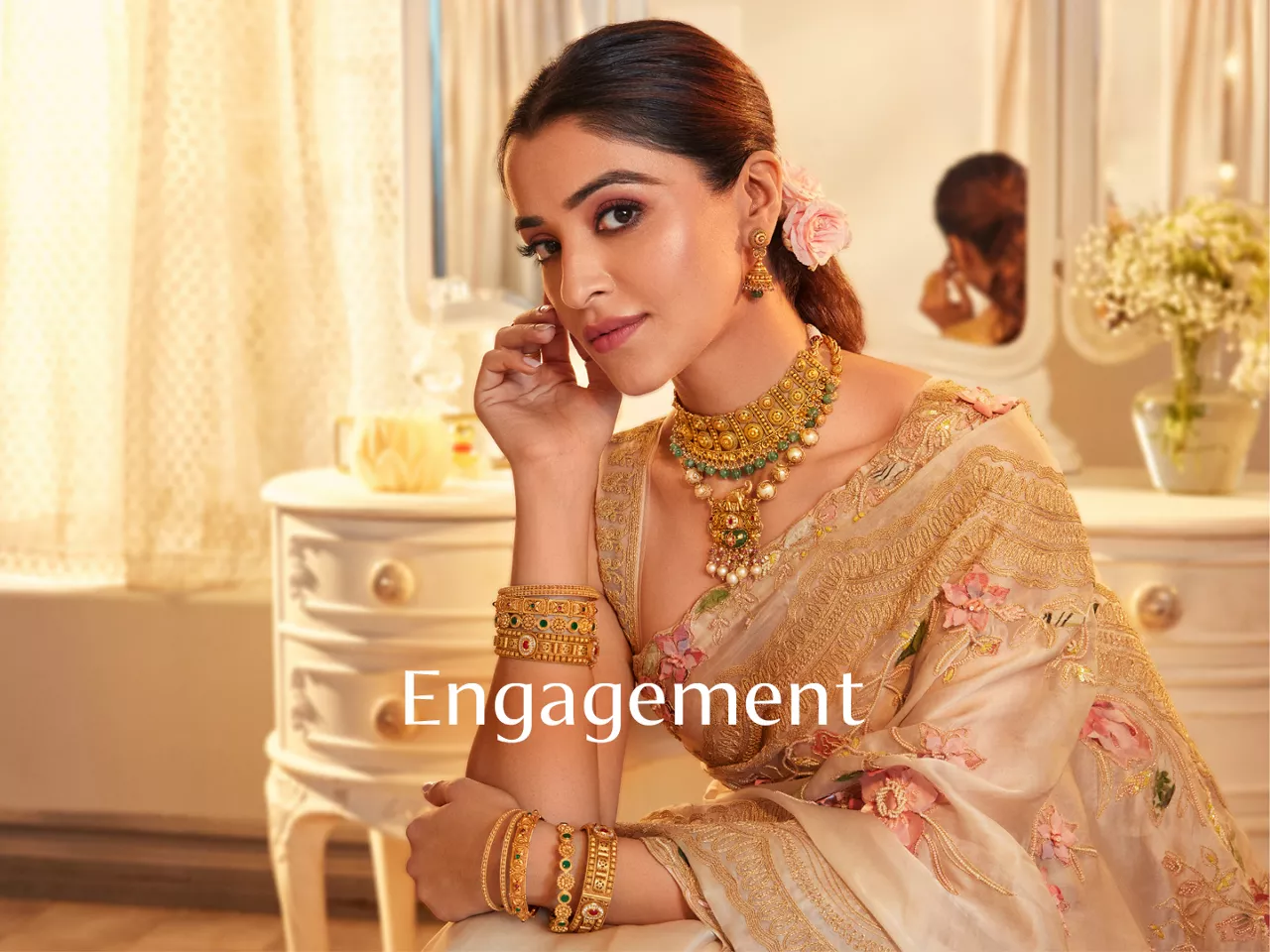 Woman in cream floral saree with gold jewellery and "Engagement" text.
