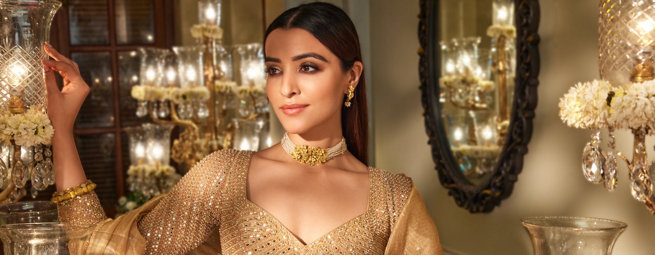 Close-up of a sophisticated woman adorned with gold choker and earrings