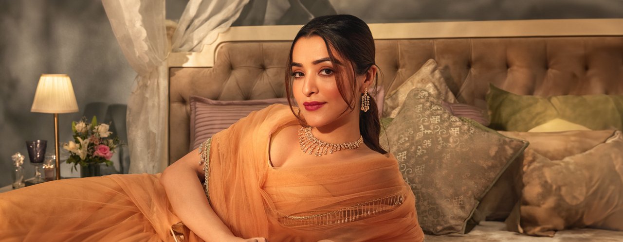 Elegant woman in orange saree wearing diamond Jewellery